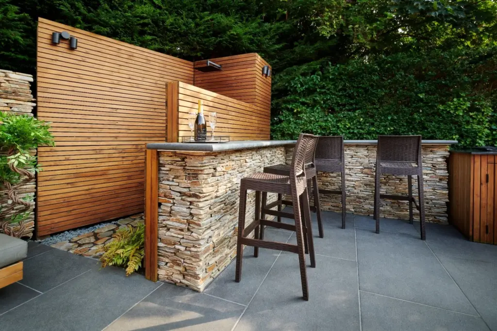 Outdoor bar with dry stone wall, cedar screening and granite paving