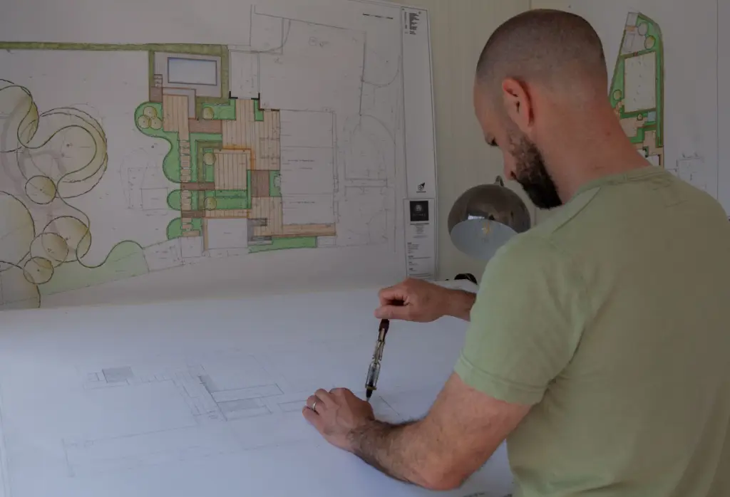 Garden masterplan drawings and material palette on the designer's desk