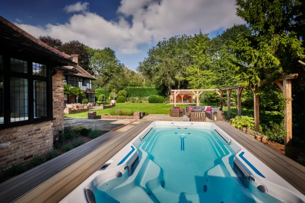 Luxury swim spa with oak pergola and country garden views