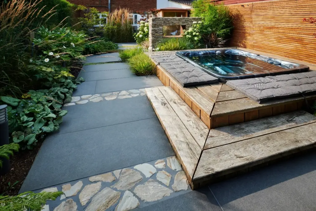 Hot tub with oak decking surround and stone mosaic pathway