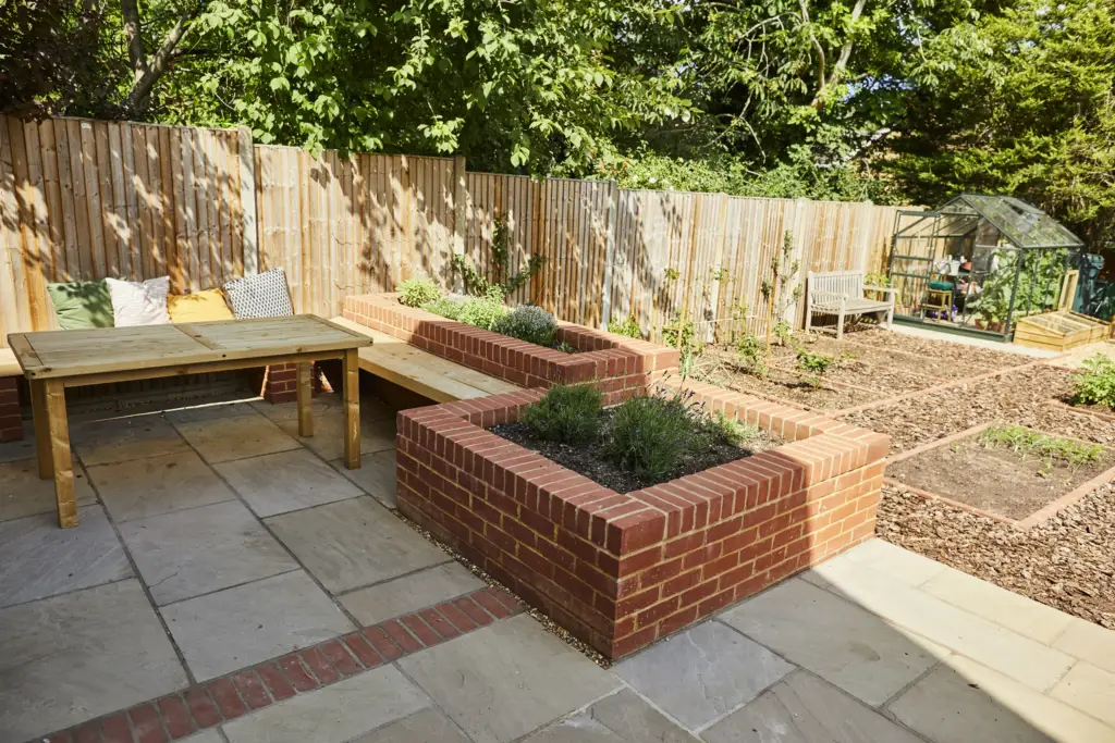 Raised brick planter with a timber bench on the terrace