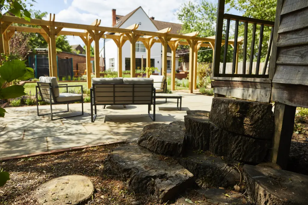 Seating beside the raised deck with log stumps and bark mulch