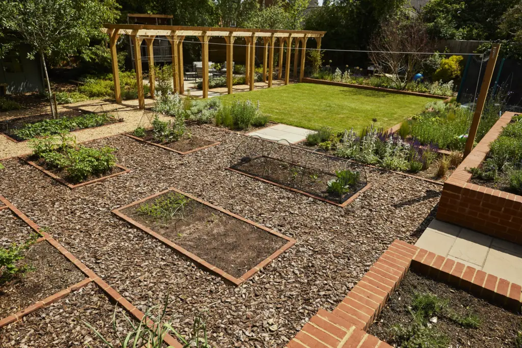 Kitchen garden beds edged in brick with bark paths