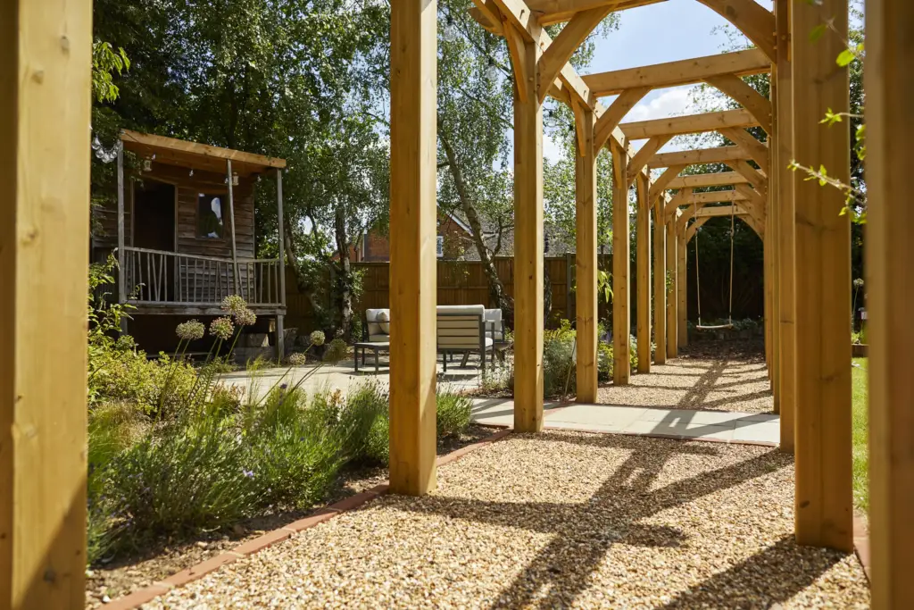 Gravel path beneath the oak pergola walk towards the summerhouse