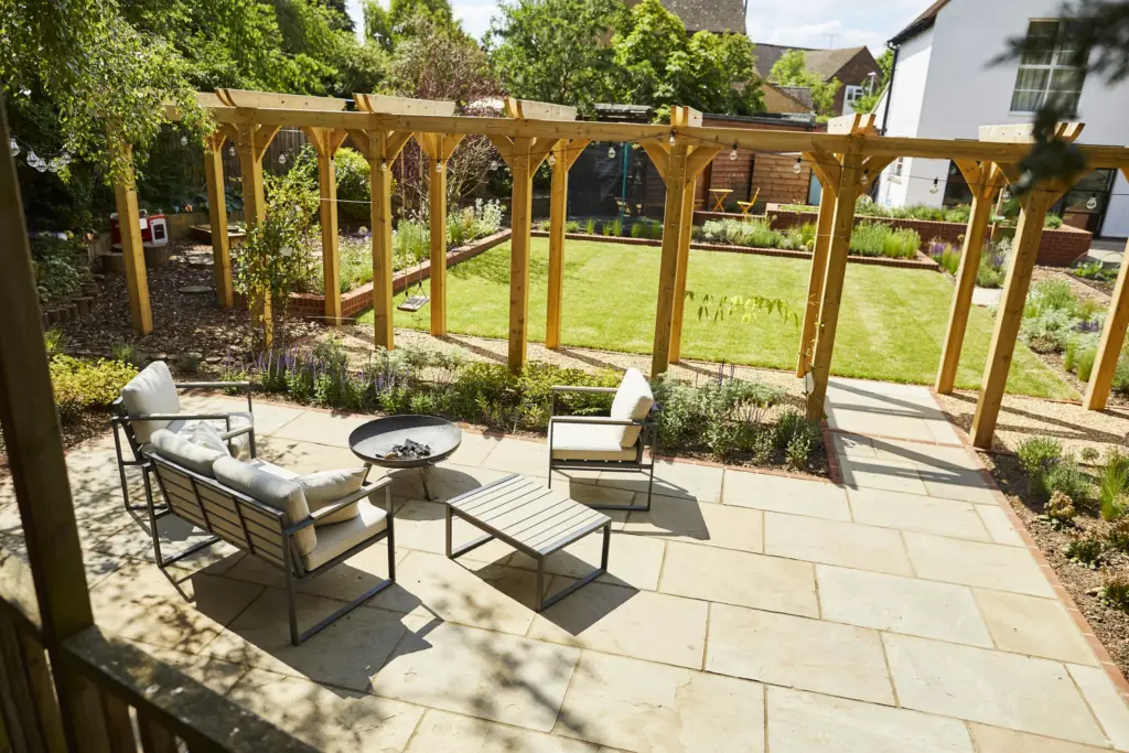 Outdoor sofas on the paved terrace beneath the pergola