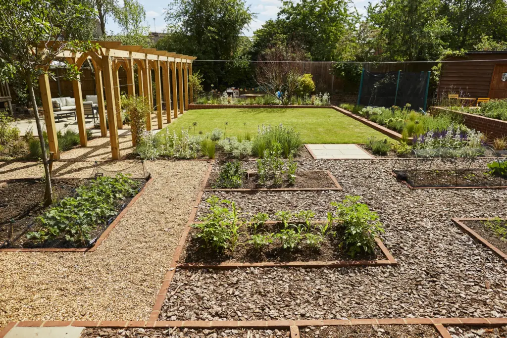 Raised vegetable beds and the pergola walk across the lawn