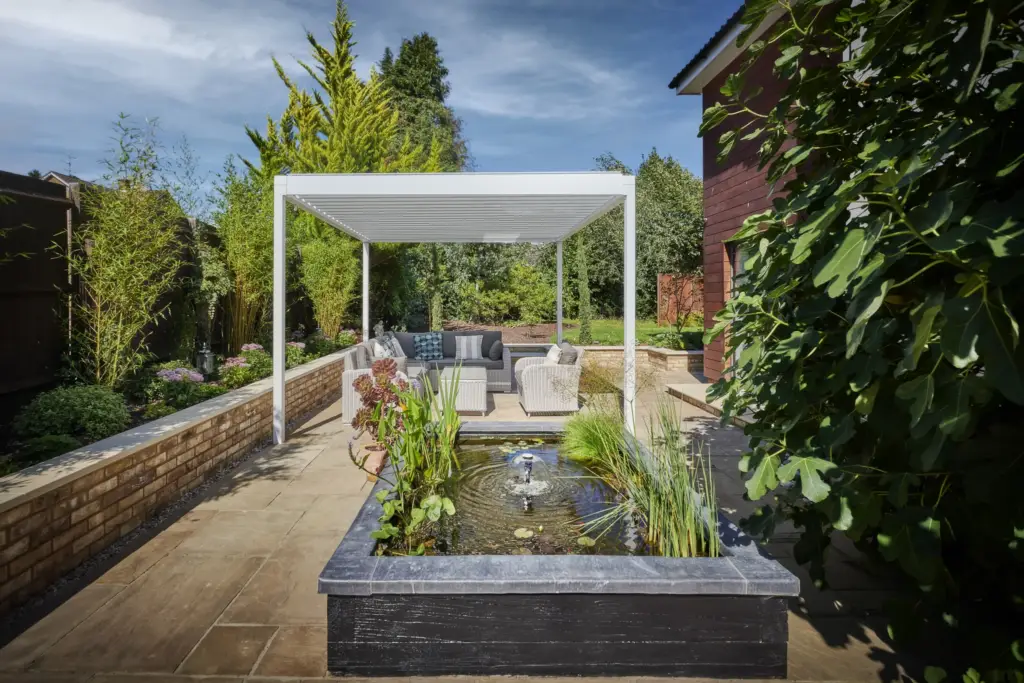 Raised water feature framed by the pergola and brick walls