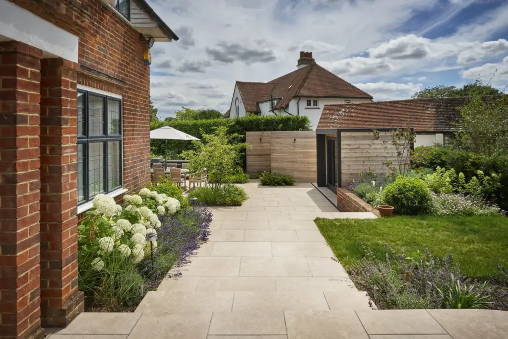 The path along the house to the garden room, edged with white hydrangeas and lavender