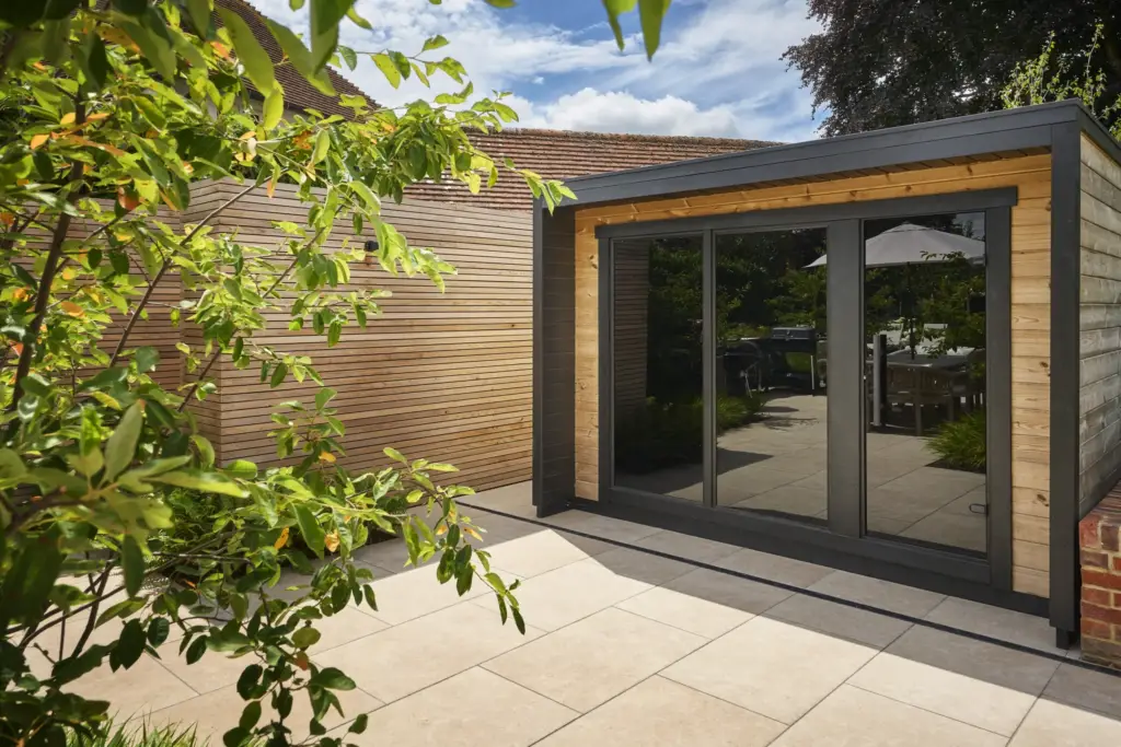 The cedar-clad sauna and changing room unit with its glazed doors beside the terrace