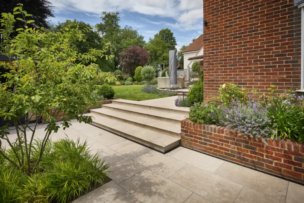 Steps up to the terrace beside the house, with planting either side