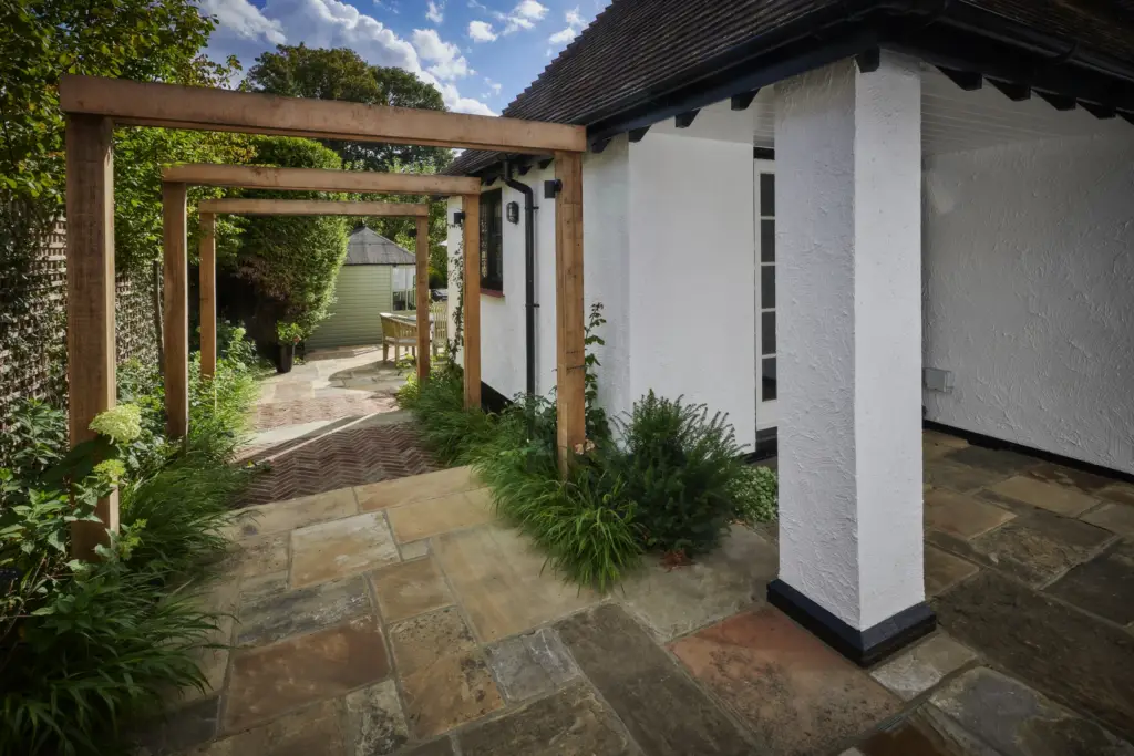 Oak pergola posts and Yorkstone paving beside the house